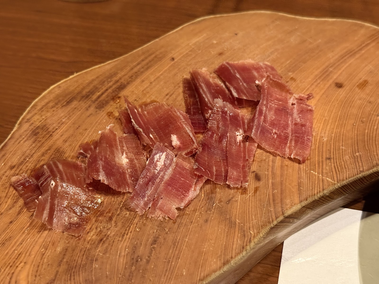 耳付きの木の板に並べた手切りの生ハム。